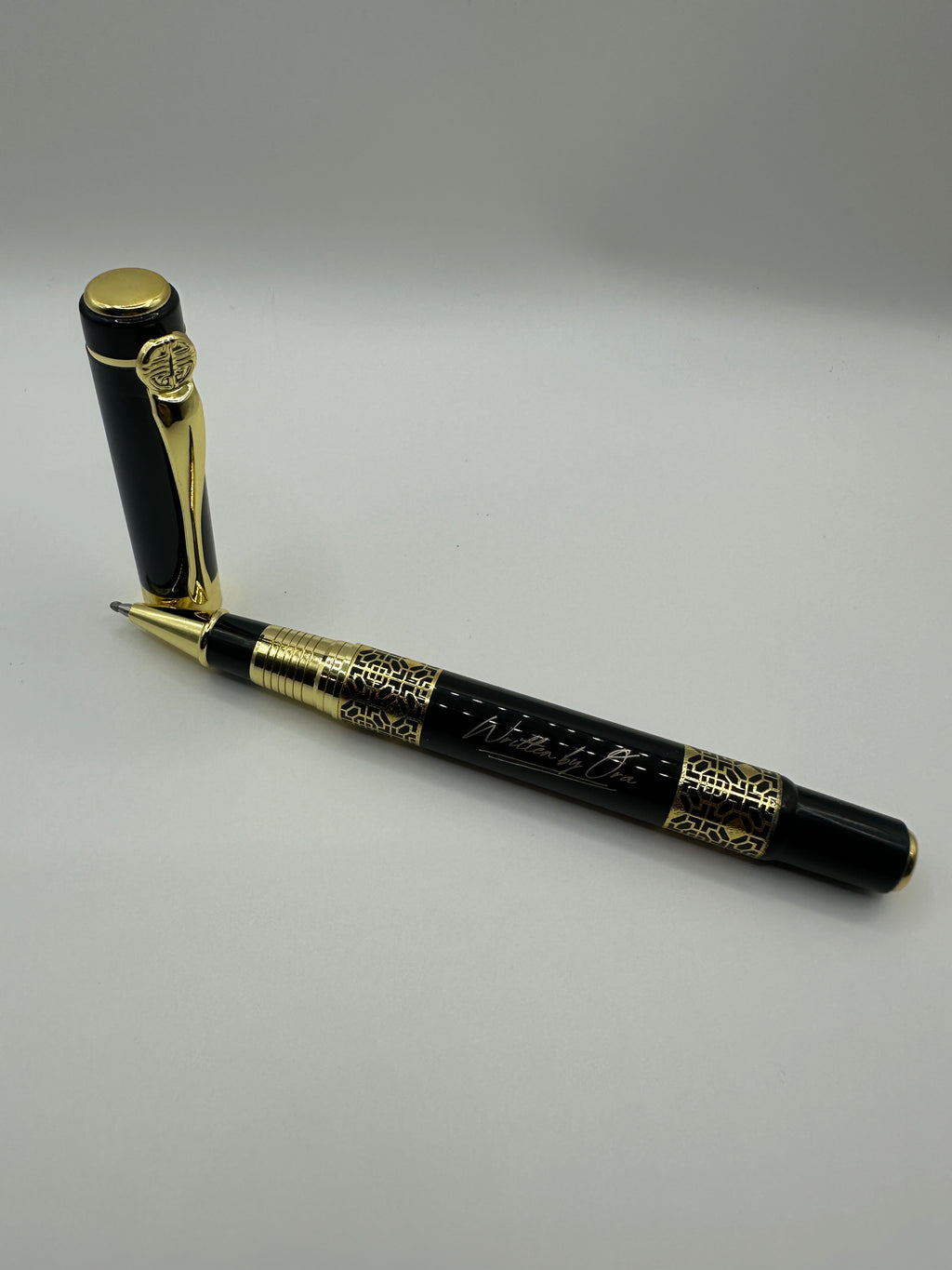 “Elegant Written by Ora rollerball pen resting on a walnut executive desk” 