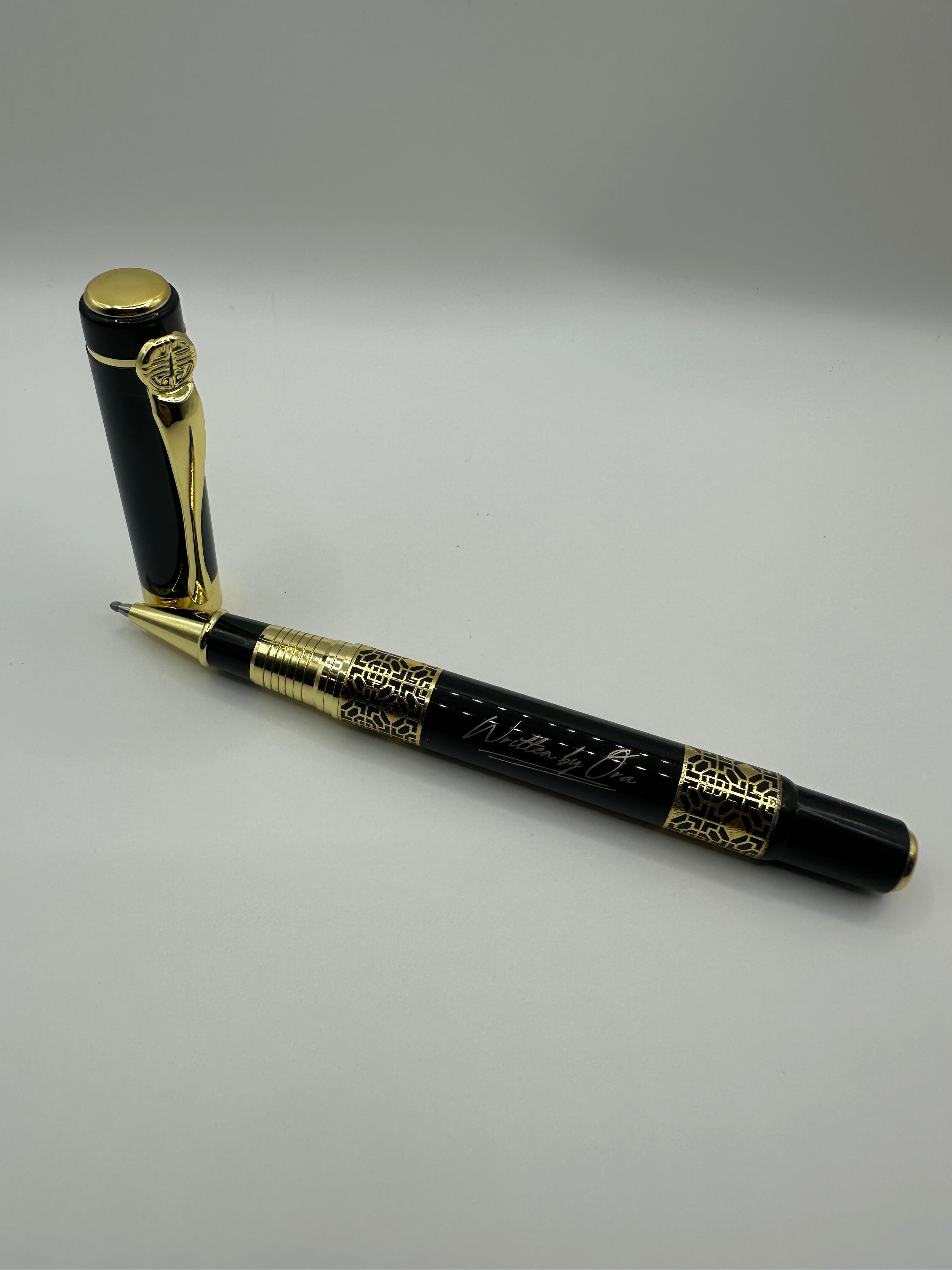 “Elegant Written by Ora rollerball pen resting on a walnut executive desk” 