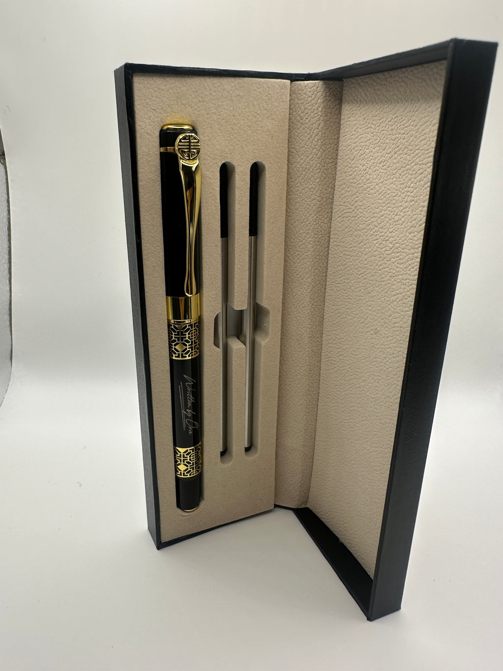 “Minimal studio photograph of a Written by Ora rollerball pen with reflective metallic details”