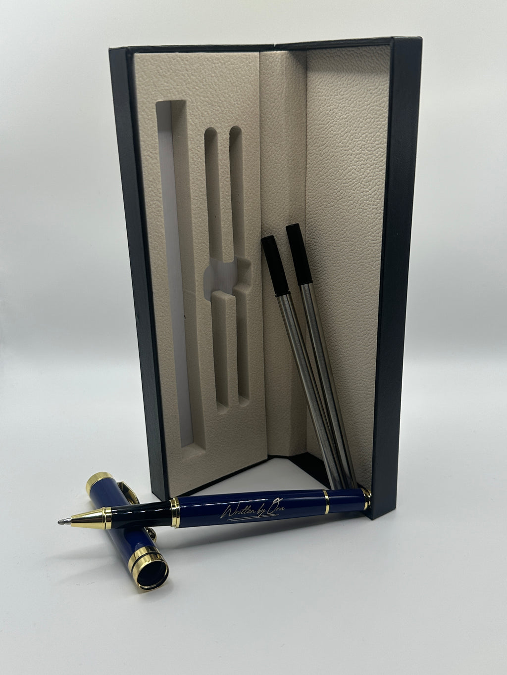 Blue pen with gold accents on a white surface next to an open black and beige pen case.