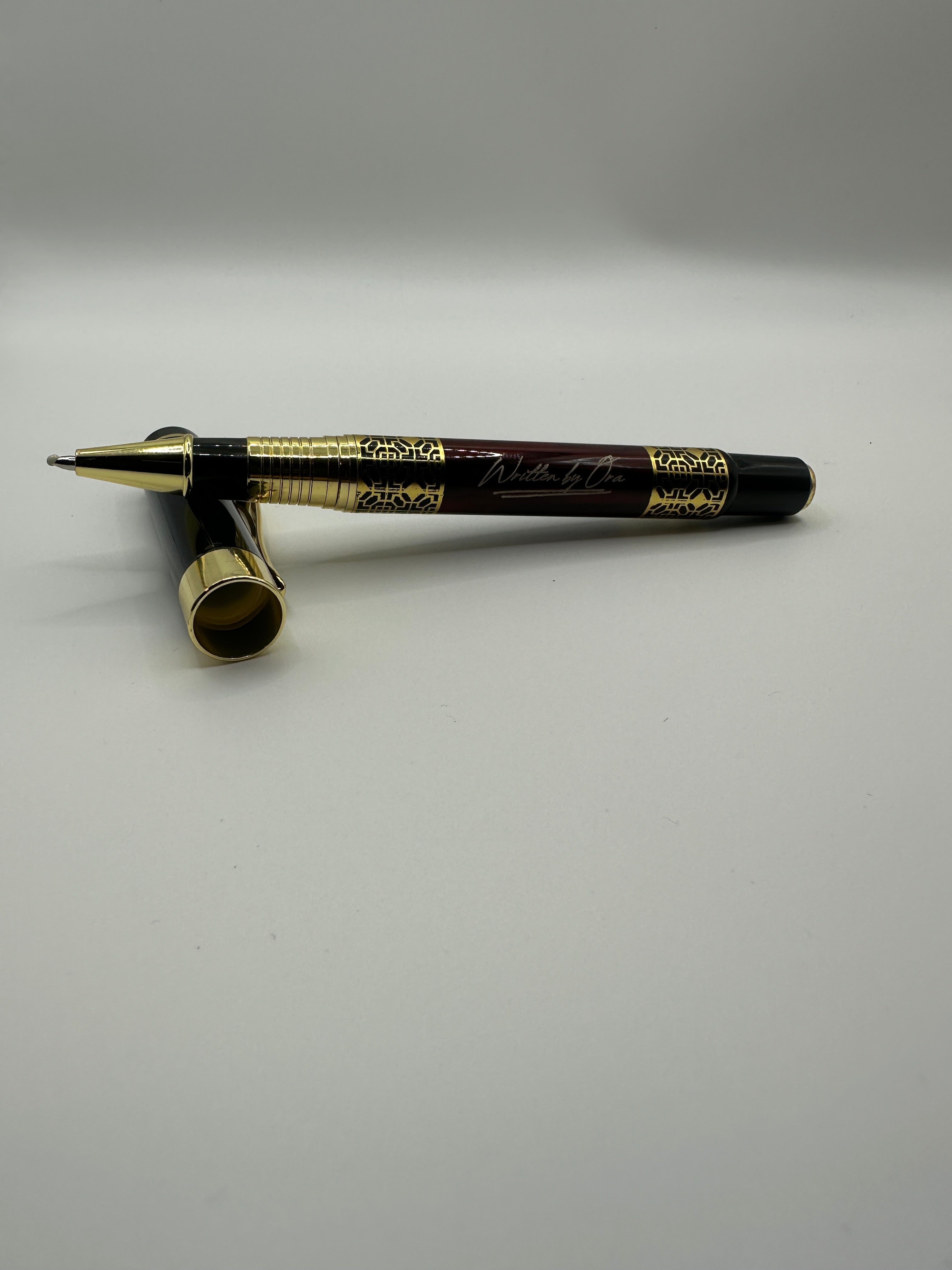 Written by Ora luxury rollerball pen with polished gold accents and black lacquer finish
